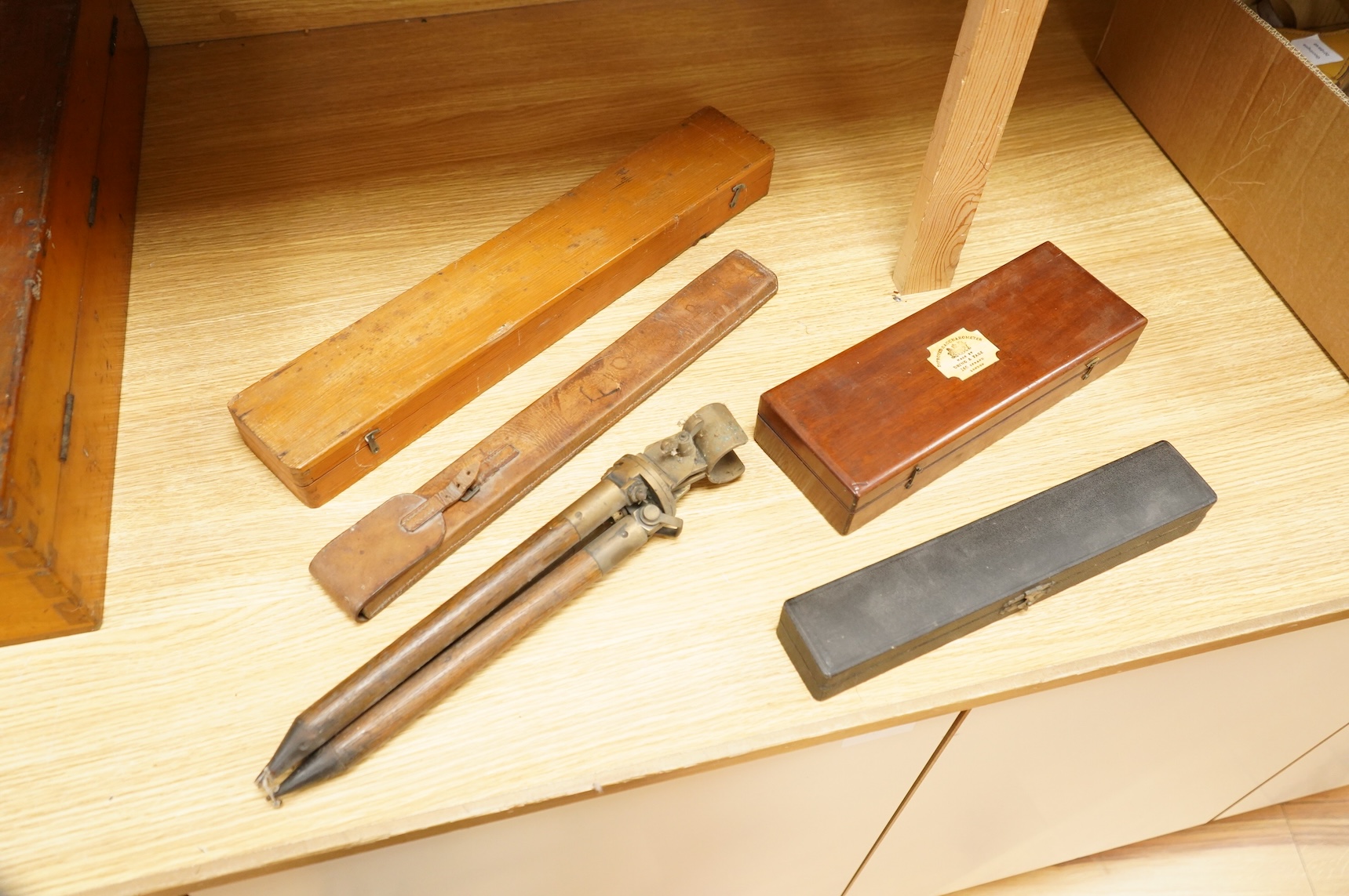 Five scientific instruments, comprising; a rolling parallel rule, pine boxed, 48cm wide; an early 20th century boxwood and brass Alidade, by J. Hicks, 8, 9 & 10, Hatton Garden, leather cased; an oak and brass tripod, sta